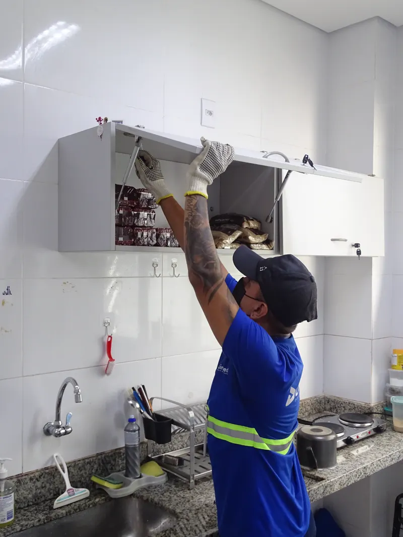 Técnico da Desinsect fazendo aplicação dentro do armário da cozinha