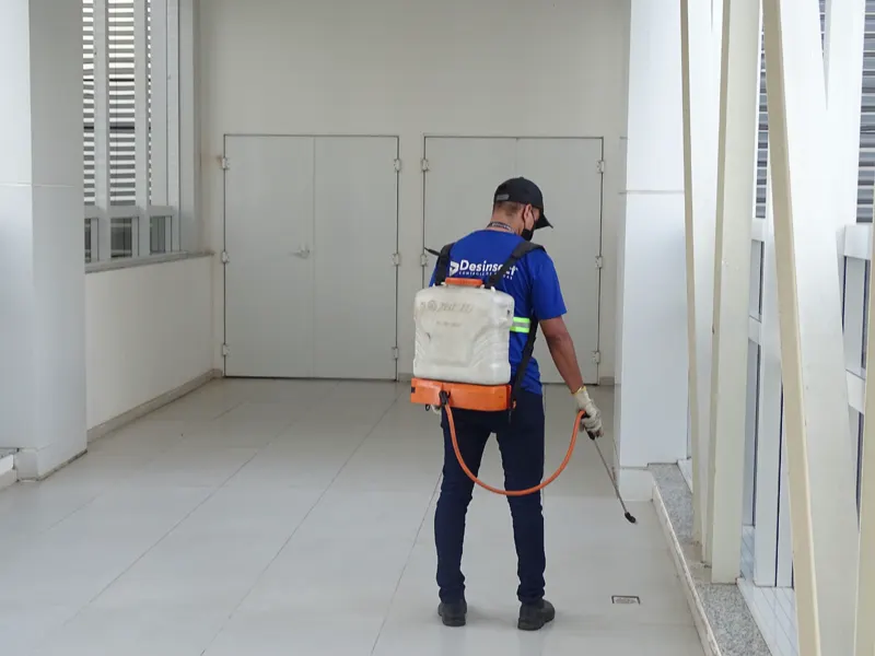 Técnico da Desinsect fazendo aplicação no corredor de um prédio