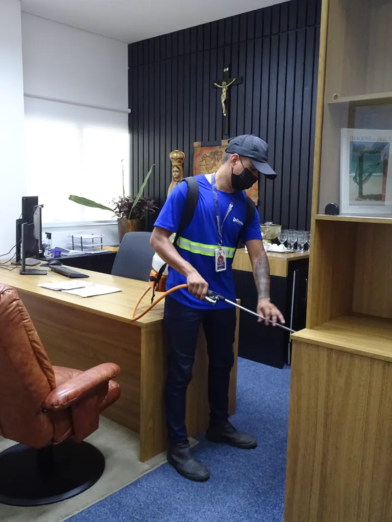 Técnico da Desinsect com pulverizador costal em atendimento a um gabinete